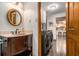 Traditional powder room featuring beautiful wood vanity, designer mirror, and adjacent laundry area at 2452 Camp Mitchell Rd, Grayson, GA 30017