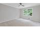 Bedroom with neutral color palette, carpet, ceiling fan, and a large window at 3751 Cherokee Se Pl, Marietta, GA 30067