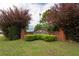 Landscaped Oak Hill community sign with brick base and lush green foliage on a cloudy day at 40 Oak Hill Dr, Covington, GA 30016