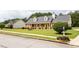 Charming brick home featuring a welcoming front porch, yellow shutters, and lush green lawn at 40 Oak Hill Dr, Covington, GA 30016