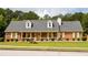 Charming brick home featuring a welcoming front porch, yellow shutters, and lush green lawn at 40 Oak Hill Dr, Covington, GA 30016