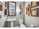 Modern powder room showcasing a pedestal sink, toilet, decorative masks, and art on the walls at 270 17Th Nw St # 3606, Atlanta, GA 30363