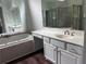 Bright bathroom featuring a soaking tub, mirrored walls, and a vanity with ample counter space and cabinetry at 421 Congress Pkwy, Lawrenceville, GA 30044