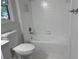 This bathroom features a white tub with an all-white tile surround and silver hardware at 421 Congress Pkwy, Lawrenceville, GA 30044