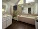 Bathroom with large tub, glass shower, double mirror, and plenty of vanity space at 421 Congress Pkwy, Lawrenceville, GA 30044