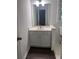 Bathroom vanity with a white countertop, white cabinets, mirror, and wood-look flooring at 421 Congress Pkwy, Lawrenceville, GA 30044