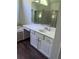 Bathroom vanity with a large mirror, white cabinets, white sink, and dark flooring at 421 Congress Pkwy, Lawrenceville, GA 30044