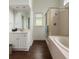 A full bathroom featuring a shower, a soaking tub, and white cabinets with a sink at 421 Congress Pkwy, Lawrenceville, GA 30044