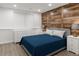 Bedroom featuring a bed with blue bedding, a wood accent wall, and light-colored flooring at 421 Congress Pkwy, Lawrenceville, GA 30044