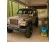 Covered carport area with a Jeep Wrangler and garden soil, adding functionality and style at 421 Congress Pkwy, Lawrenceville, GA 30044