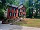 Charming two-story brick home featuring manicured landscaping and steps leading to the entrance at 421 Congress Pkwy, Lawrenceville, GA 30044