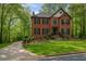 Beautiful brick home featuring mature landscaping, a manicured lawn, and a long driveway leading up to the house at 421 Congress Pkwy, Lawrenceville, GA 30044