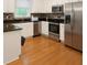 A kitchen is filled with stainless steel appliances, black countertops and white cabinets at 421 Congress Pkwy, Lawrenceville, GA 30044