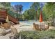 Community pool area featuring a hot tub, lounge chairs, tables, and beautiful wooded surroundings at 421 Congress Pkwy, Lawrenceville, GA 30044