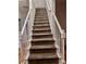 Carpeted staircase with white banisters and newel posts at 421 Congress Pkwy, Lawrenceville, GA 30044