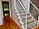 Carpeted staircase with white banisters and hardwood flooring at 421 Congress Pkwy, Lawrenceville, GA 30044
