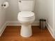 Standard white toilet in a half bath with hardwood floors and white trim at 421 Congress Pkwy, Lawrenceville, GA 30044