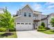 Charming gray two-story home with a white garage door, front porch, and manicured landscaping at 553 Onyx Lndg, Marietta, GA 30064
