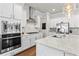Well-lit kitchen features stainless appliances, a modern range hood, and elegant countertops at 553 Onyx Lndg, Marietta, GA 30064