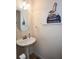 Cozy powder room with a pedestal sink, round mirror, and chic fashion-themed decor at 6245 Hickory Lane Cir, Union City, GA 30291