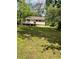 A green backyard with a wooden deck on a charming home surrounded by lush trees and a well-maintained lawn at 6399 Boca Grande Blvd, Forest Park, GA 30297
