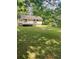 A green backyard with a wooden deck on a charming home nestled among mature trees on a sunny day at 6399 Boca Grande Blvd, Forest Park, GA 30297