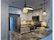 Modern kitchen with granite countertops, stainless steel appliances, and elegant pendant lighting at 1101 Juniper Ne St # 1506, Atlanta, GA 30309