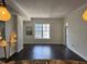 Cozy living room featuring hardwood floors, a large window, and stylish light fixtures above the kitchen bar at 1101 Juniper Ne St # 1506, Atlanta, GA 30309