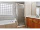 Bathroom features a glass enclosed shower next to a soaking tub and a double sink vanity at 4230 Glen Vista Ct, Duluth, GA 30097