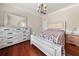 Bedroom with wood floors, a decorative dresser, and a queen size bed with floral comforter at 871 Wisteria View Ct, Dacula, GA 30019