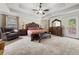Spacious bedroom with tray ceilings, featuring a seating area and an ornate wooden bedroom suite at 871 Wisteria View Ct, Dacula, GA 30019