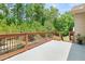 Outdoor deck space with wood railing and a view of the lush backyard foliage at 871 Wisteria View Ct, Dacula, GA 30019