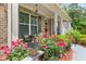 Inviting front porch with seating area, surrounded by vibrant roses and manicured landscaping at 871 Wisteria View Ct, Dacula, GA 30019