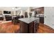 Kitchen with granite island, dark cabinets, and an open view of the dining and living areas at 871 Wisteria View Ct, Dacula, GA 30019