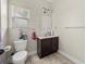 Bathroom with toilet, vanity, and a mirror, accented with decor and a window for natural light at 871 Wisteria View Ct, Dacula, GA 30019