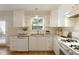 Bright kitchen with granite countertops, white cabinets, and stainless steel sink at 1092 Old Roswell Rd, Roswell, GA 30076