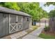 Outbuilding with gray siding, white trim, double doors and a gated backyard at 1092 Old Roswell Rd, Roswell, GA 30076