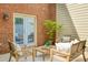 Cozy outdoor patio with brick wall, white outdoor furniture, and door leading inside at 1092 Old Roswell Rd, Roswell, GA 30076
