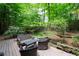 Wooden backyard patio surrounded by lush green trees and beautiful landscaping at 1560 Bubbling Creek Ne Rd, Atlanta, GA 30319