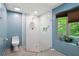 Modern bathroom with a walk-in shower, bright blue walls, and a view of nature from a window at 1560 Bubbling Creek Ne Rd, Atlanta, GA 30319