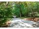 Scenic driveway entrance with lush landscaping and mature trees, providing a private and inviting approach at 1560 Bubbling Creek Ne Rd, Atlanta, GA 30319