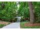 Long driveway leading to the home surrounded by lush trees and landscaping, offering privacy and curb appeal at 1560 Bubbling Creek Ne Rd, Atlanta, GA 30319