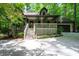 Charming home featuring a covered porch, attached garage, and inviting curb appeal with mature trees at 1560 Bubbling Creek Ne Rd, Atlanta, GA 30319