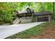 Exterior view of home with front porch, lush trees, two-car garage and nicely manicured landscaping at 1560 Bubbling Creek Ne Rd, Atlanta, GA 30319
