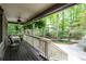 Enjoy the serene view from the porch with hanging plants, overlooking the lush greenery and landscaped yard at 1560 Bubbling Creek Ne Rd, Atlanta, GA 30319