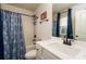 Bathroom featuring a shower-tub combination with stylish blue curtains and a sleek vanity with modern fixtures at 17 Ridgeline Nw Way, Cartersville, GA 30121