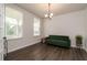 Bright living room featuring wood floors, a green sofa, and two windows that provide natural light at 17 Ridgeline Nw Way, Cartersville, GA 30121