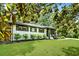 Beautiful white brick home with dark trim and lush green lawn framed by mature trees and landscaped bushes at 233 Dorris Sw Dr, Marietta, GA 30060