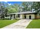 Charming white brick home with black trim, a well-kept lawn, and a convenient covered carport at 233 Dorris Sw Dr, Marietta, GA 30060