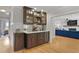 Wet bar featuring custom cabinetry, elegant countertops, and mirrored backsplash leading into a spacious living room at 233 Dorris Sw Dr, Marietta, GA 30060